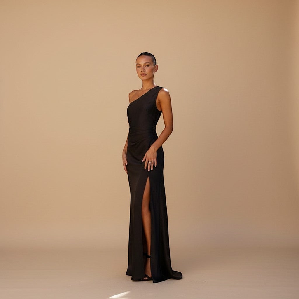 Yemelia black satin sleeveless evening gown with high slit and refined neckline. Floor-length, figure-flattering.