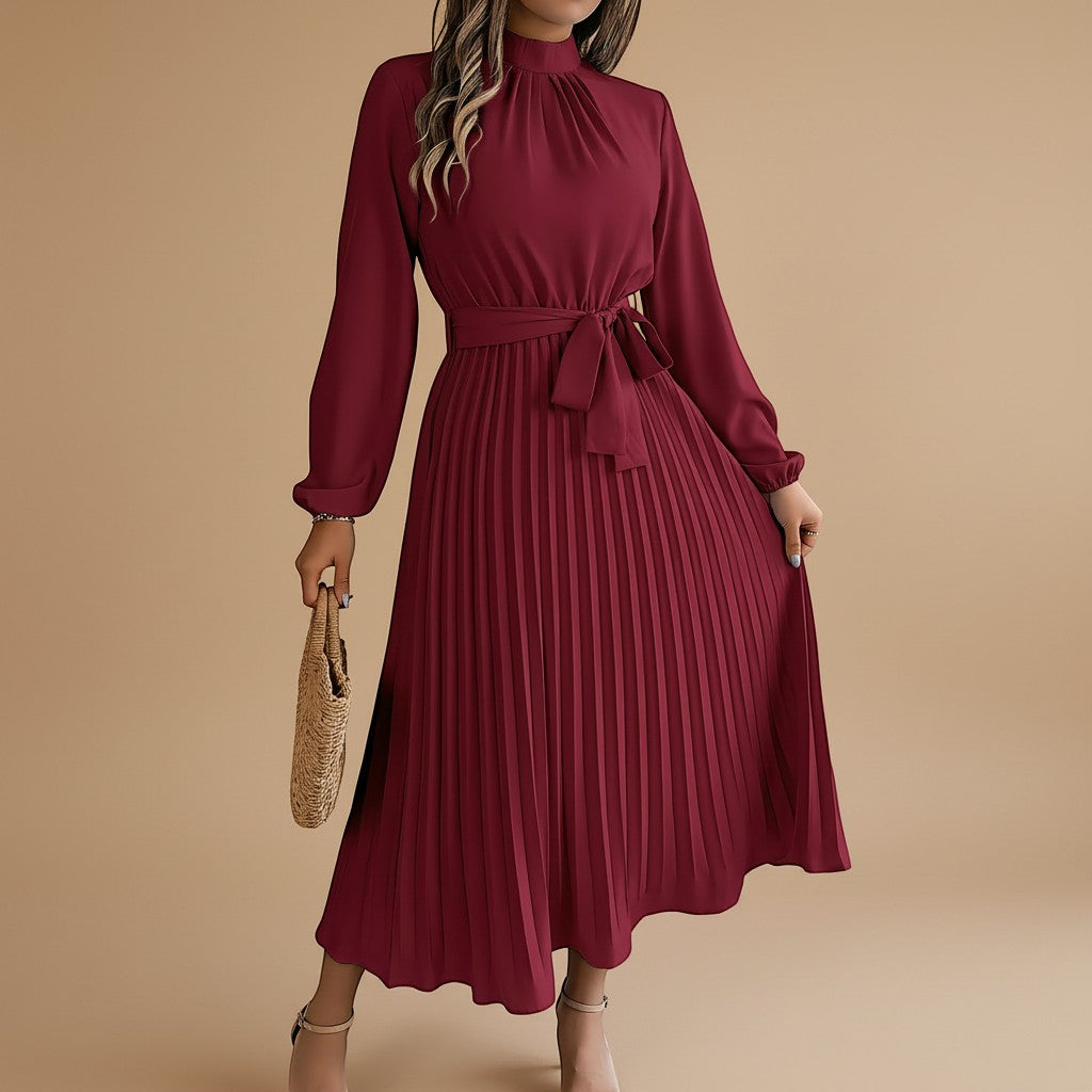 Yemelia burgundy long sleeve pleated midi dress with high neck and waist tie. Elegant, flowing silhouette for events.