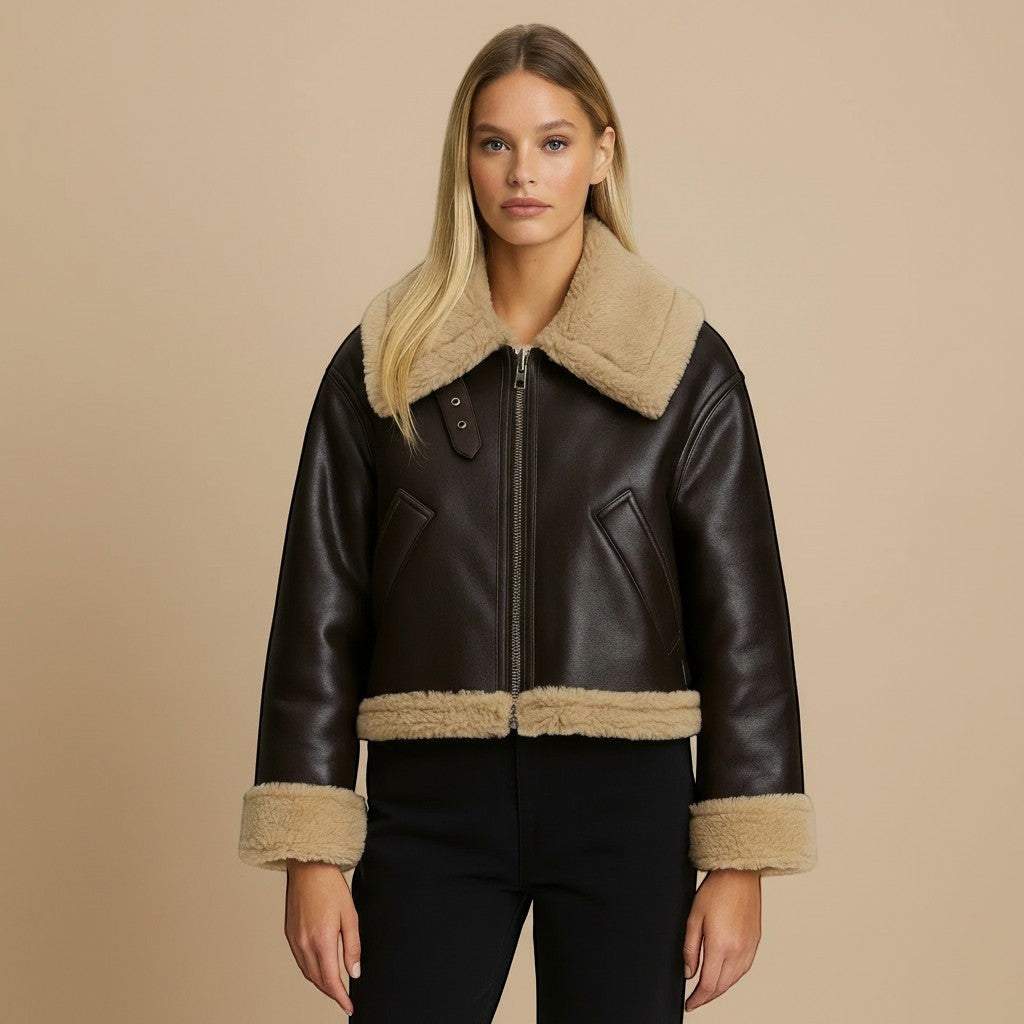 Yemelia dark brown faux leather jacket with tan shearling trim on collar, cuffs, and hem. Zip front closure.